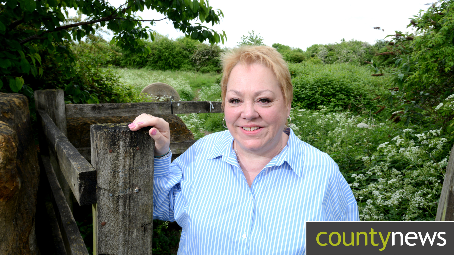 Cllr Nicola Clarke leaning on a fence post with a field behind