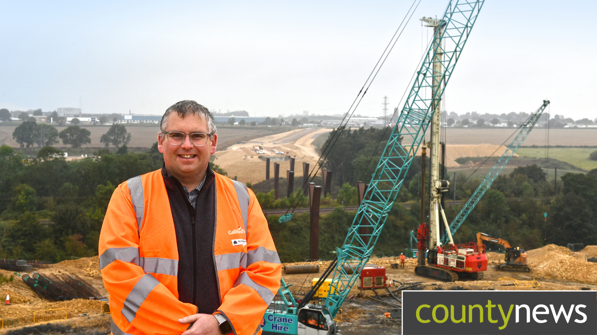 A construction worker stood in front a working highways site