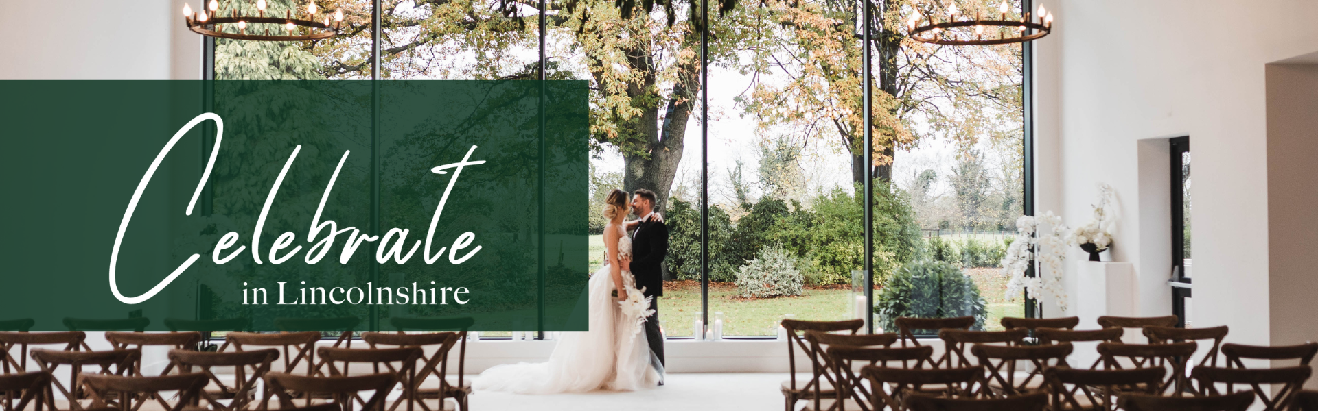 A bride and groom stood in front of empty chairs at a ceremony arms around each other