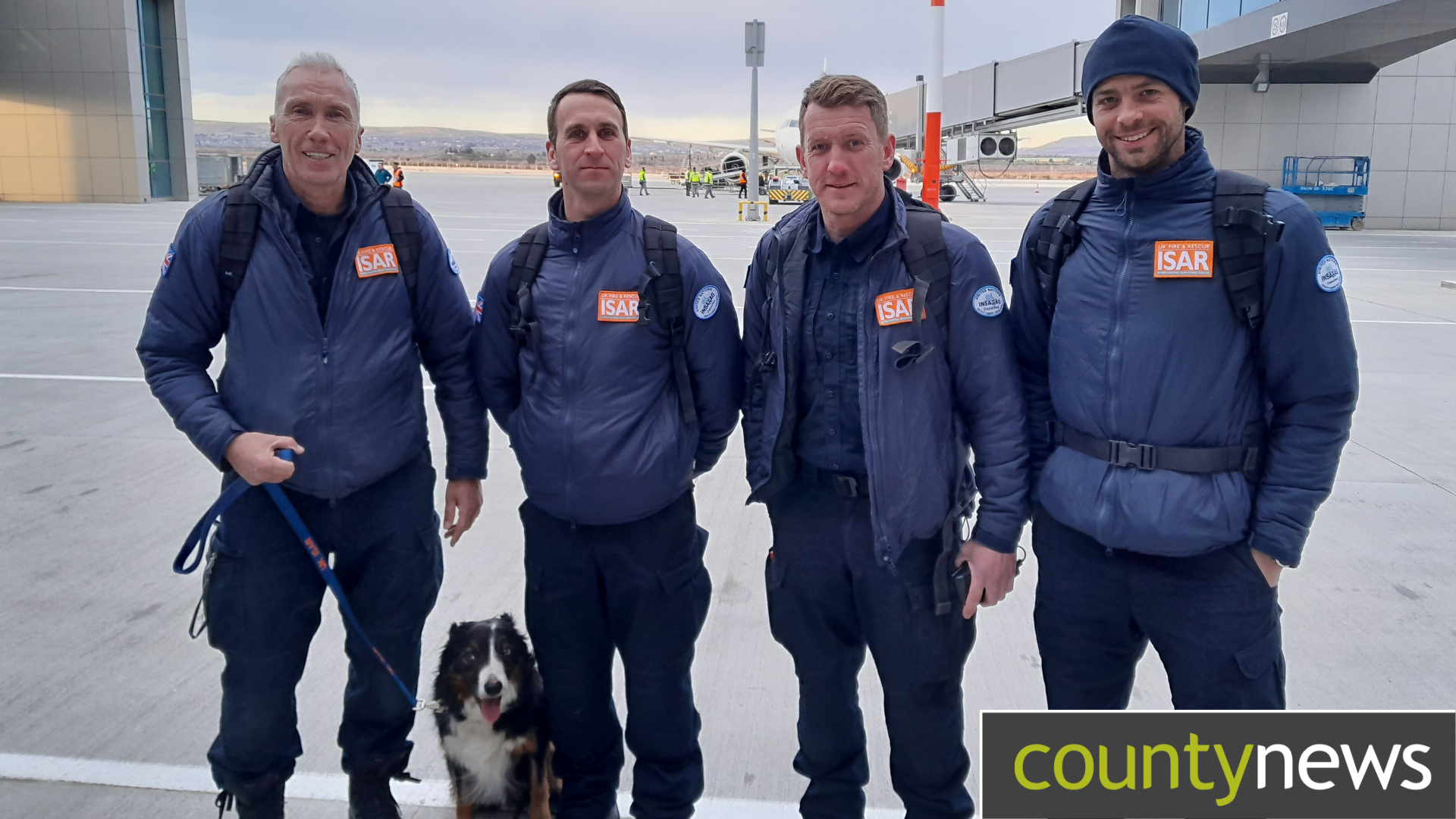 Firefighters stand proudly with Colin the rescue dog