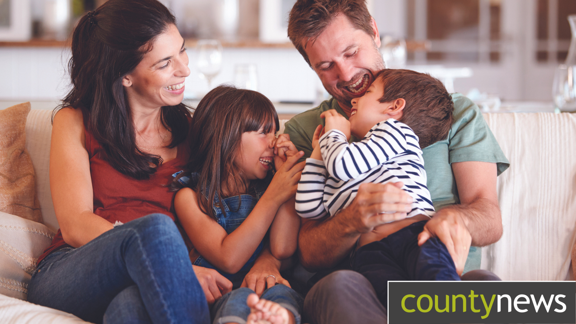 A family sat together on a sofa