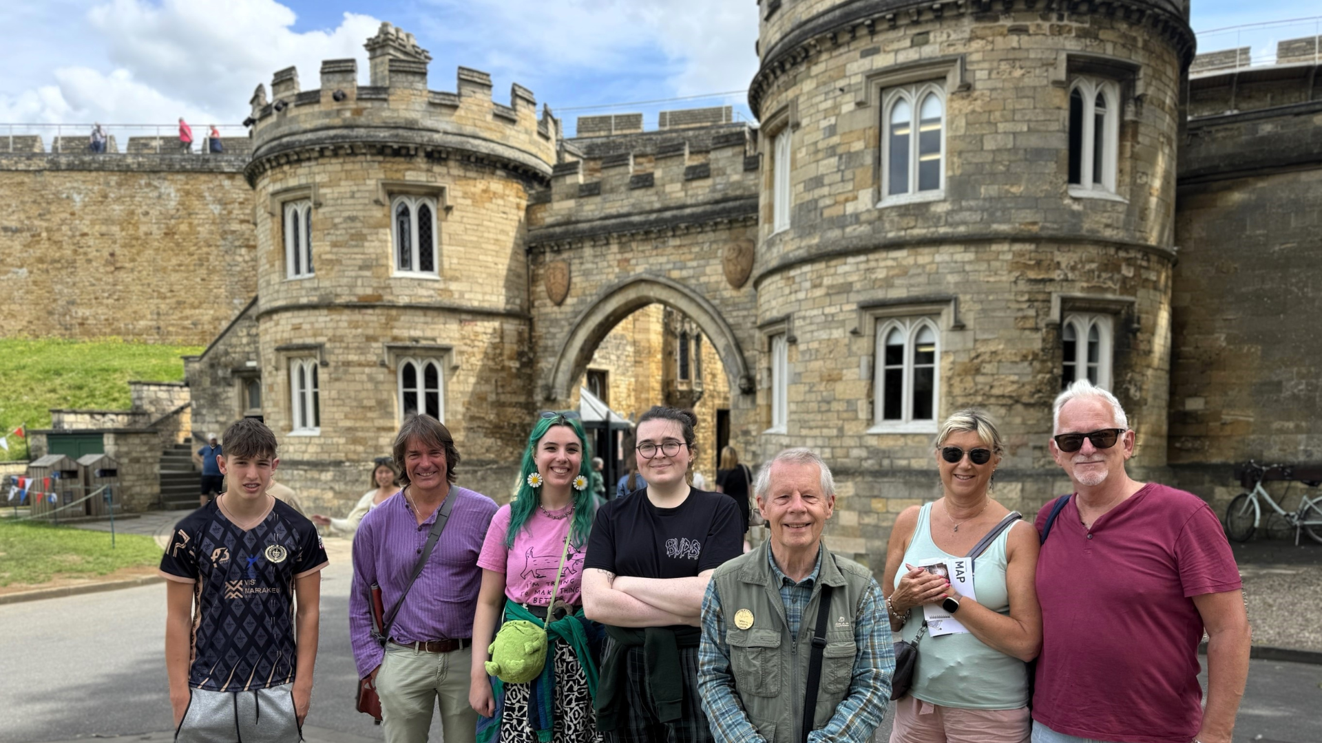 A tour and tour guide at Lincoln Castle stood at the entrance gate