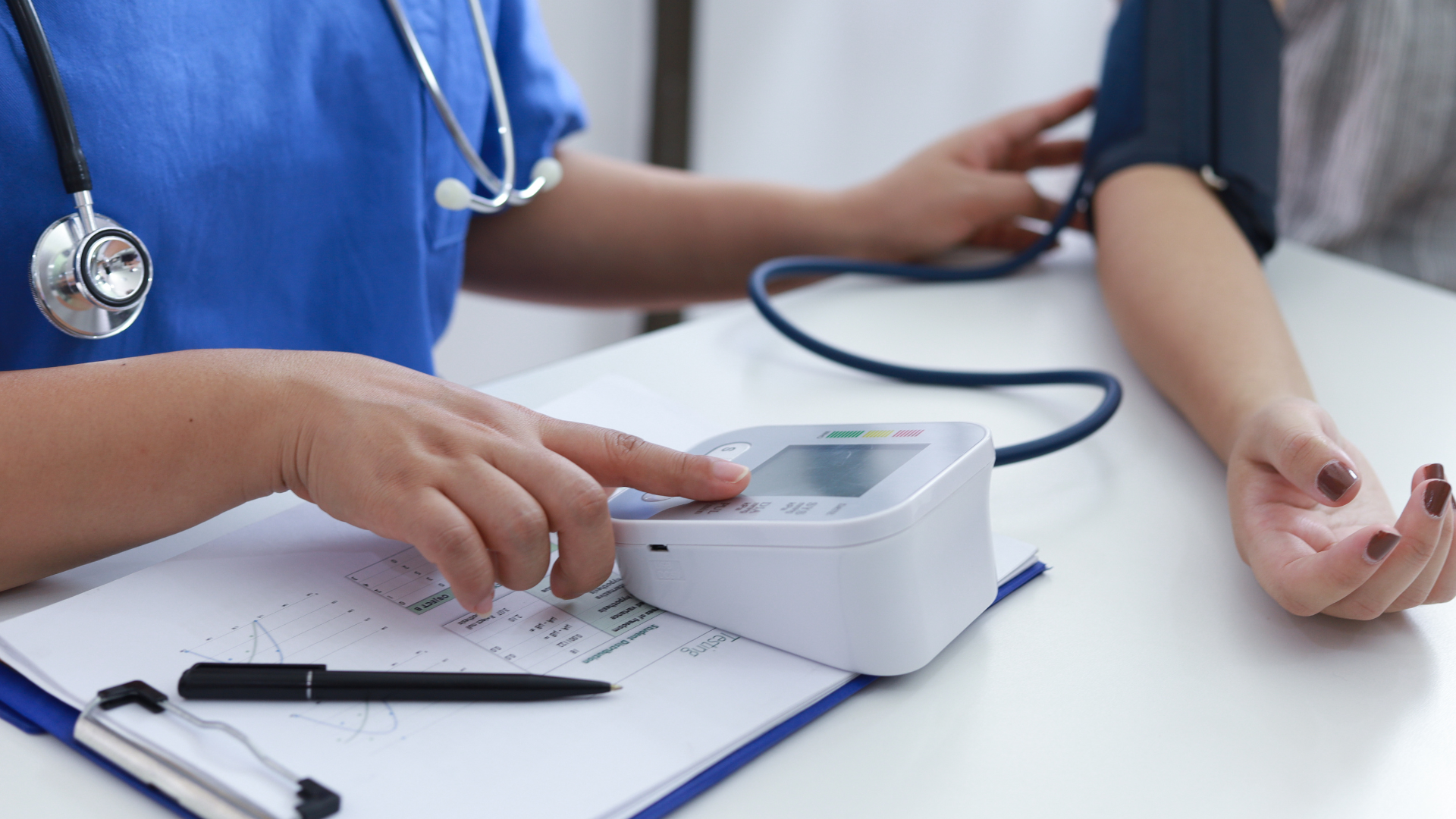 A nurse checks a patients blood pressure.