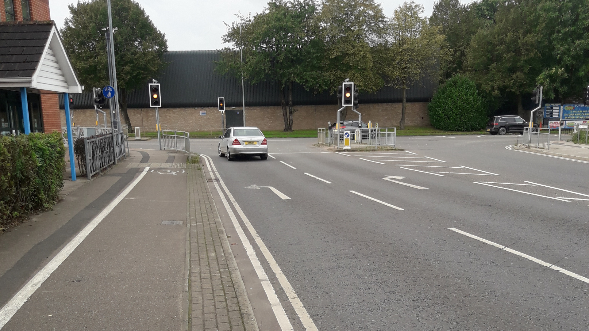 A junction with two lanes and traffic lights for pedestrians to cross