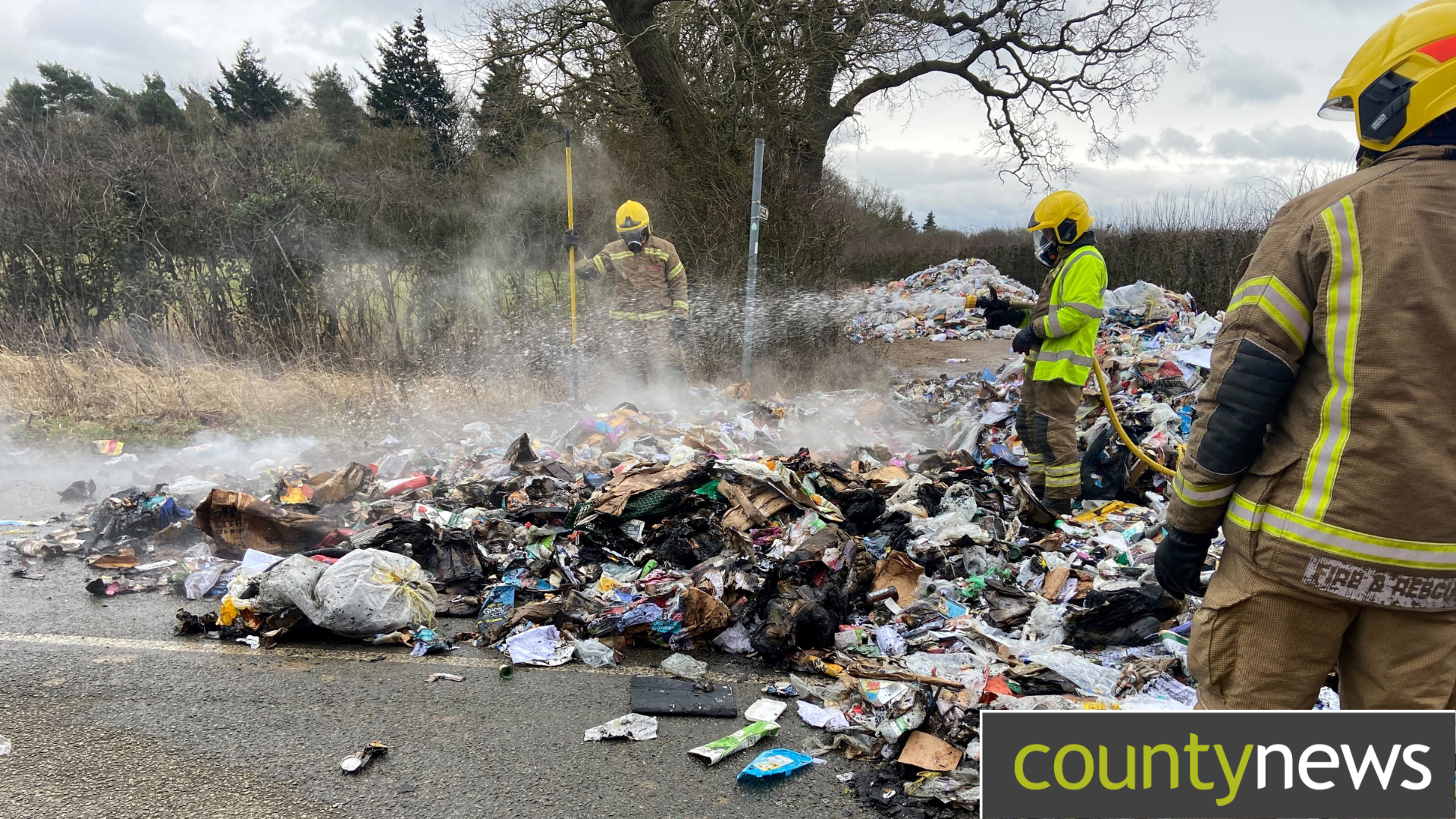 A group of firefights look at the remains of a recycling fire